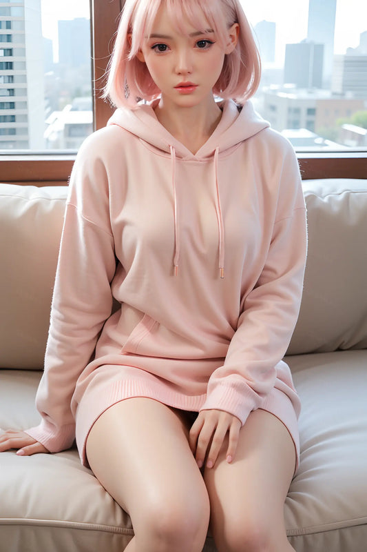 Dria sex doll cool composed direct stare, warm brown eyes, short straight pastel pink bob with blunt fringe, soft coral lips, blush pink oversized pullover hoodie with white drawstring detail, bare sculpted thighs pressed together, both hands resting on knees, seated on white cushioned sofa with large floor-to-ceiling window and blurred city skyline background – full-body seated shot – lifelike petite Asian girl-next-door sex doll by TopLoveDoll