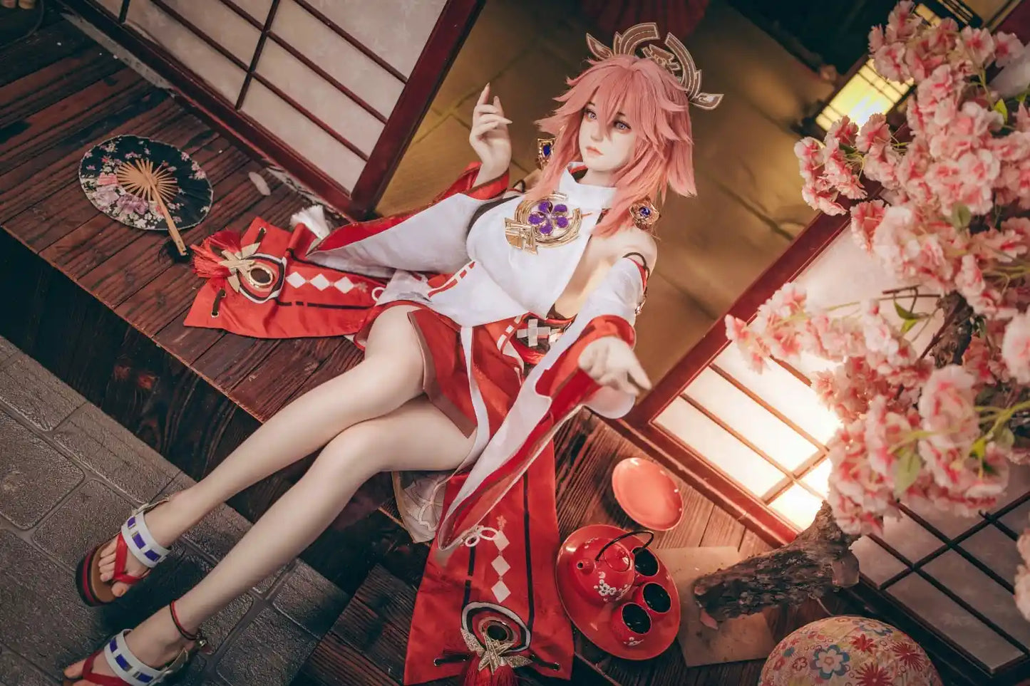  Yae Miko Genshin Impact cosplay sex doll, pink hair, sensual miko outfit, tatami room red cup – anime cosplay lifesize doll by TopLoveDoll,  red bell anklet, wooden geta sandals, Genshin Impact sex doll, sitting on the stairs, legs crossed, holding a J-style red cup, high-angle full shot, horizontal profile, doing a inviting gesture