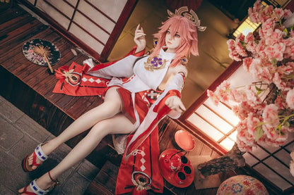  Yae Miko Genshin Impact cosplay sex doll, pink hair, sensual miko outfit, tatami room red cup – anime cosplay lifesize doll by TopLoveDoll,  red bell anklet, wooden geta sandals, Genshin Impact sex doll, sitting on the stairs, legs crossed, holding a J-style red cup, high-angle full shot, horizontal profile, doing a inviting gesture