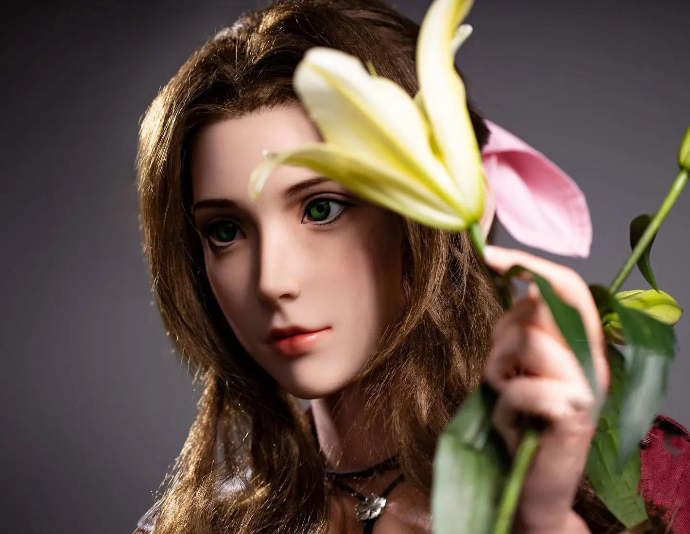 Hera, iconic green eyes, dark brown long curls hair, dark red suede jacket, white V-neck slip dress, pink bow, black choker, grey studio lighting background, holding a branch of lily– European bookish bombshell companion sex doll by TopLovedoll