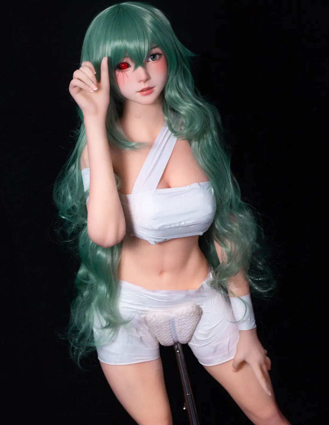 Alayah, green long wavy hair, white crop top, white shorts, dark studio lighting, Takatsuki Sen Eto Tokyo Ghoul, half-human half-ghoul, standing on a red carpet, with a steel doll stand held between the thighs, one red & black ghoul eye, one green human eye – anime cosplay fantasy sex doll by TopLoveDoll