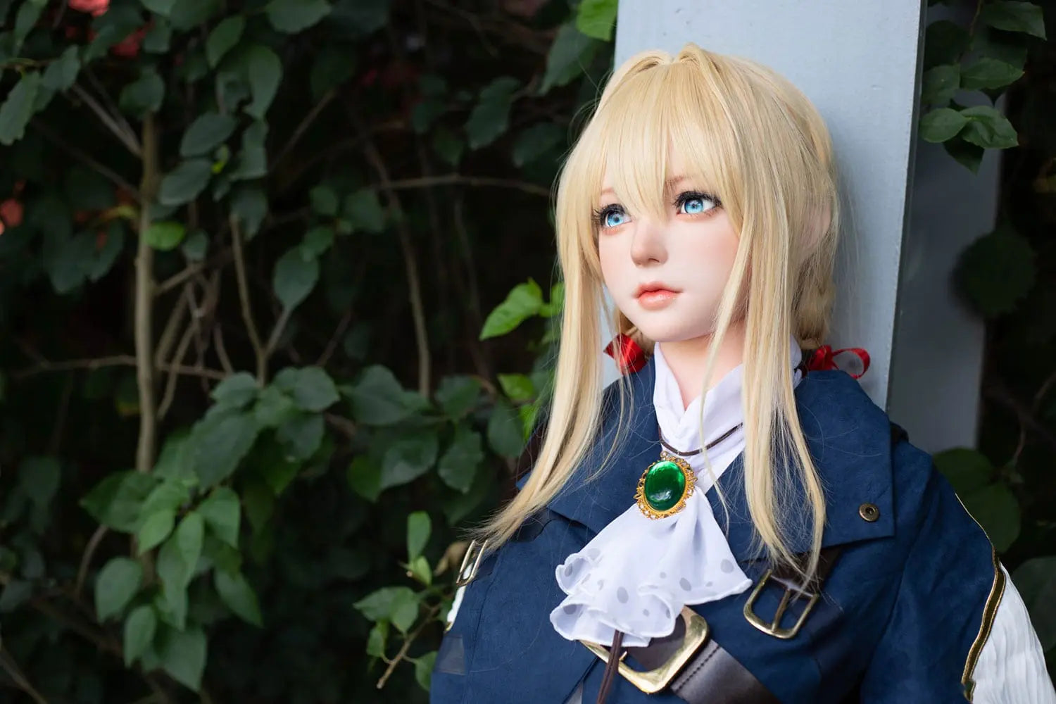 Aliana, golden straight long hair, blue eyes, navy Auto Memory Doll uniform, white apron, black leather boots, outdoor, green trees, standing against a steel pillar that's near to a lot of vines and green leaves, brown gloves, holding a brown leather suitcase, eye-level shot, face close-up, front view – Violet Evergarden cosplay anime sex doll by TopLoveDoll