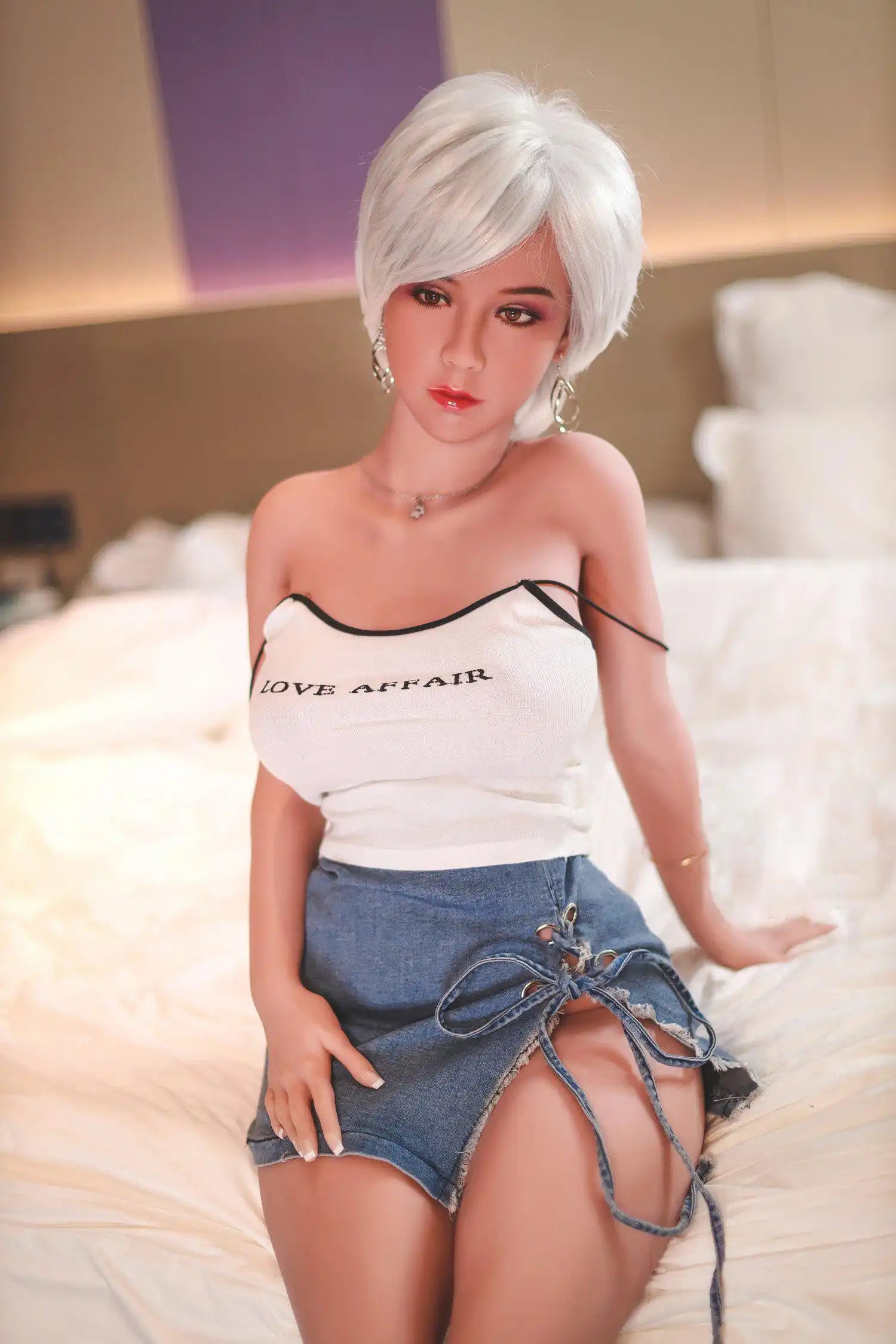 Anahi short platinum blonde hair tan skin white fitted tank denim micro skirt bold Shibuya street style pose, sitting on the hotel bed – Asian blonde pornstar sex doll by TopLoveDoll