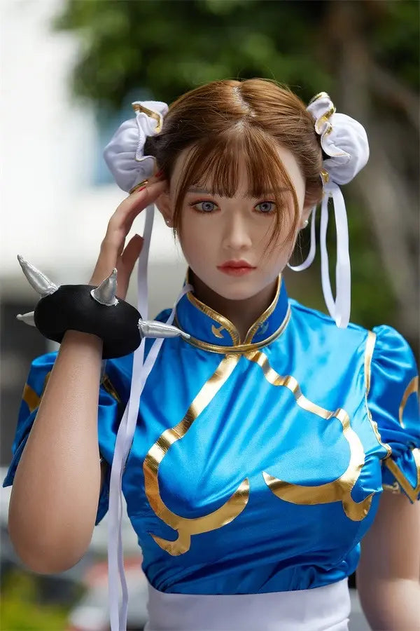 Araya Street Fighter Chun-Li cosplay sex doll, standing on a blurred park view background, grey contacts- blue qipao, high twin buns, - Asian beauty elevated by TopLoveDoll