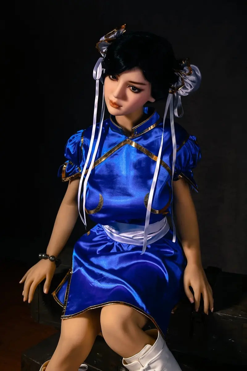 Aubriella Street Fighter Chun-Li cosplay sex doll in blue qipao on a black background, sitting on the boxes, looking puzzled- iconic blue qipao fighter fantasy by TopLoveDoll