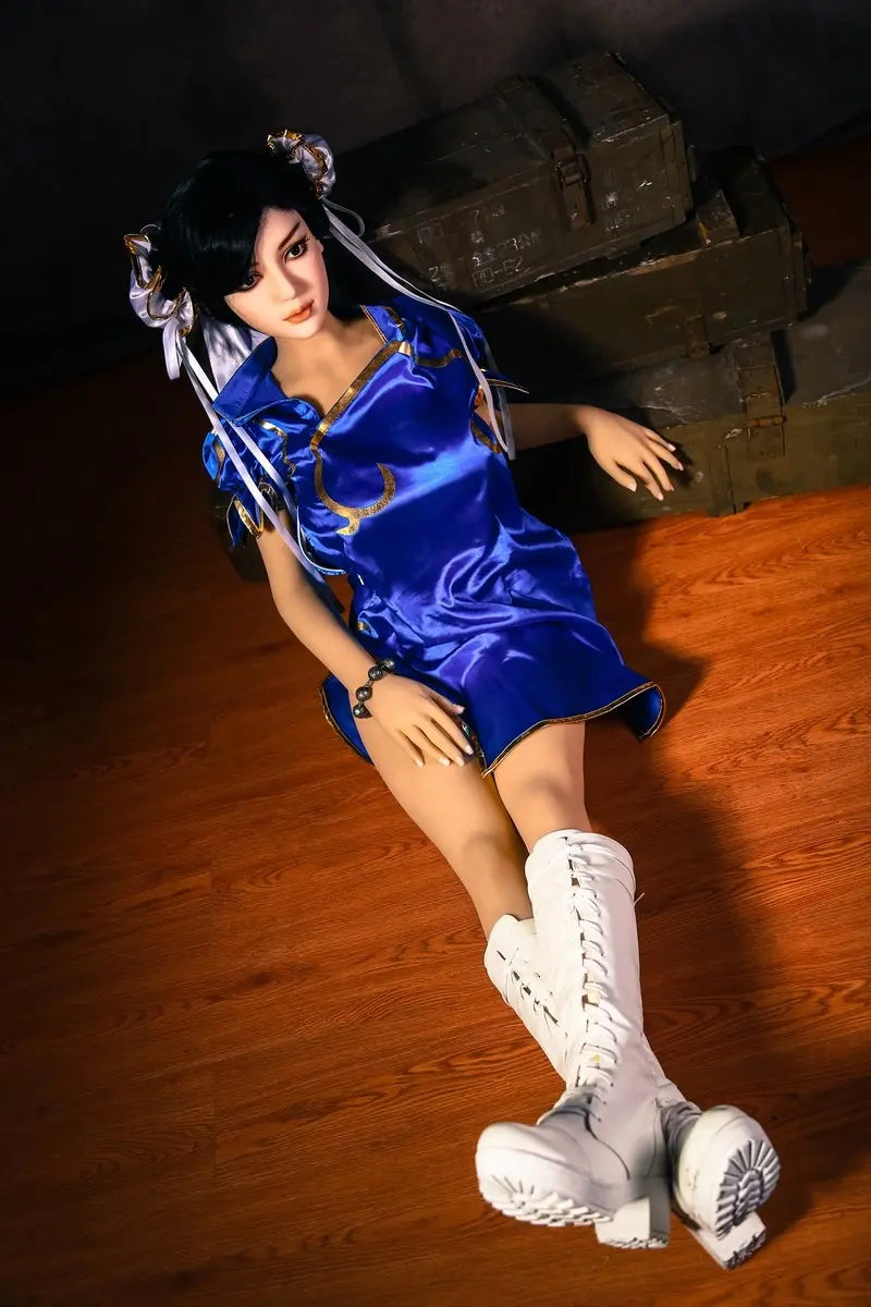 Aubriella Street Fighter Chun-Li cosplay sex doll in blue qipao on a black background, leaning against some wooden boxes, sitting on the floor- iconic blue qipao fighter fantasy by TopLoveDoll